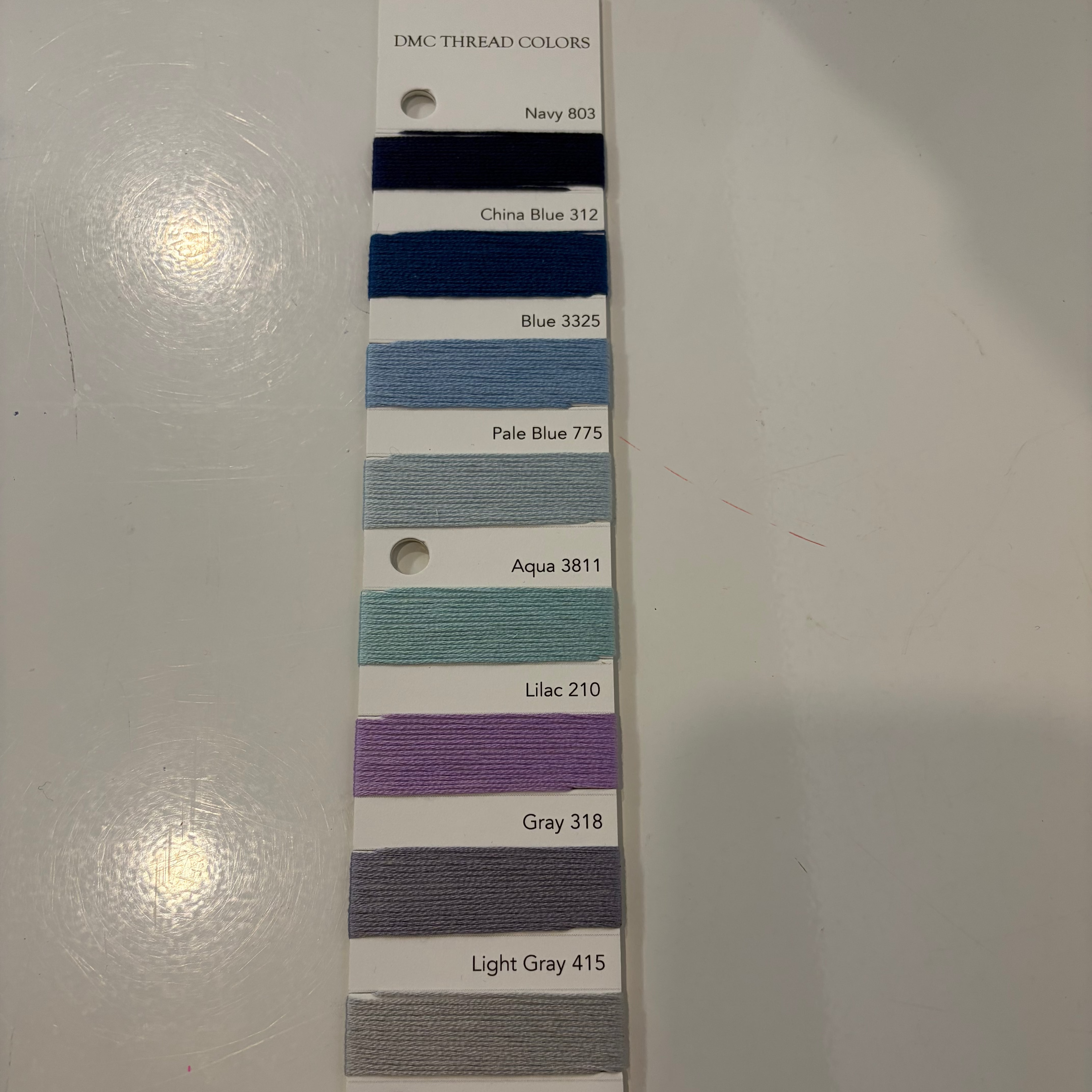 Color swatch card with various thread colors on a white background