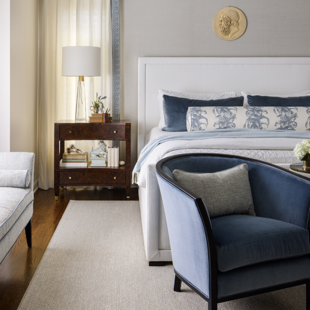 Neatly arranged bedroom with a bed, chair, and nightstand.