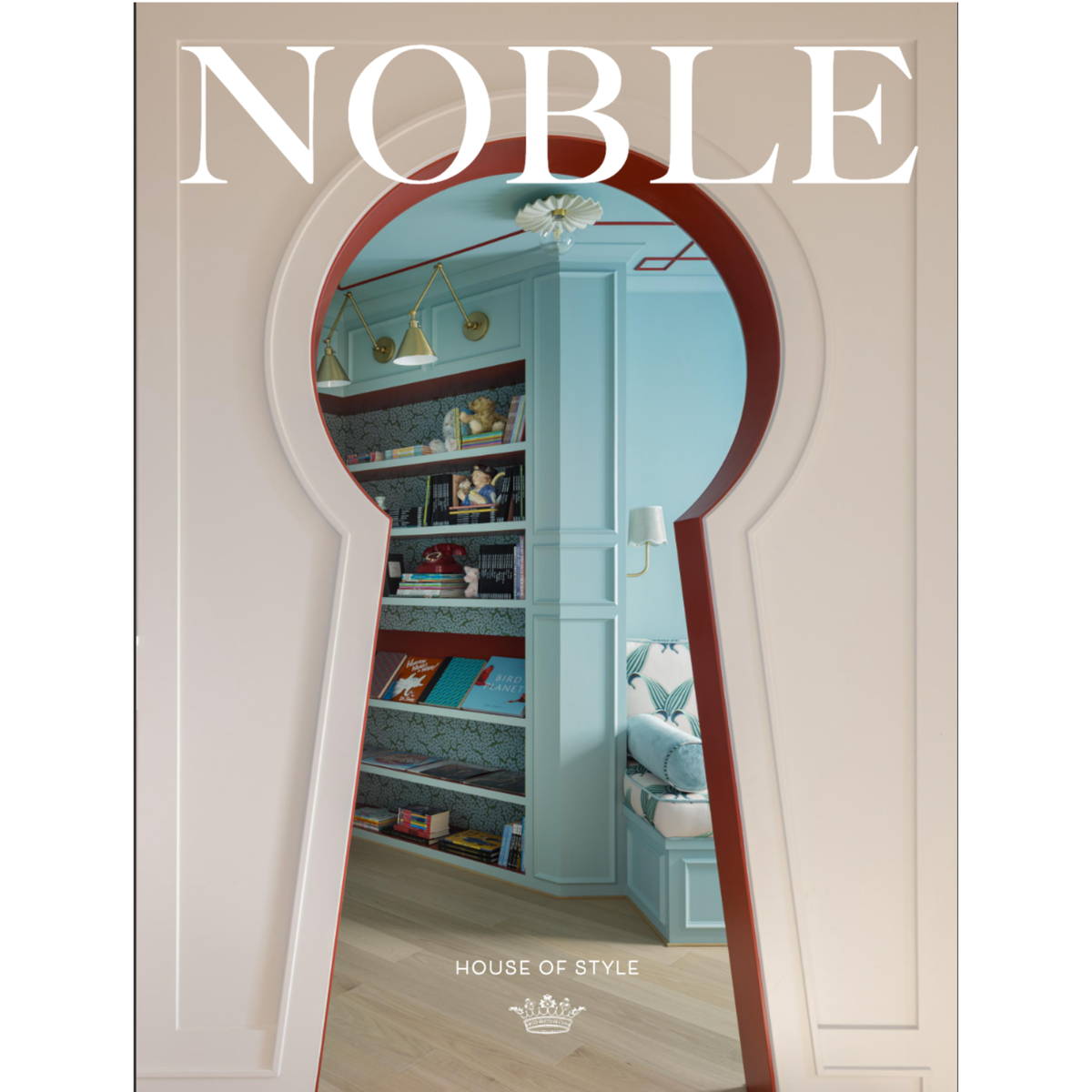 A magazine or book cover titled NOBLE with a large white serif title at the top and 'HOUSE OF STYLE' near the bottom. The cover features a keyhole-shaped cutout revealing a styled interior room with light blue walls, built-in shelving, books, lamps, and a bench.